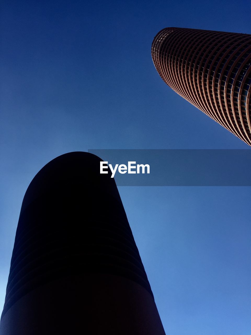 Low angle view of modern building against blue sky