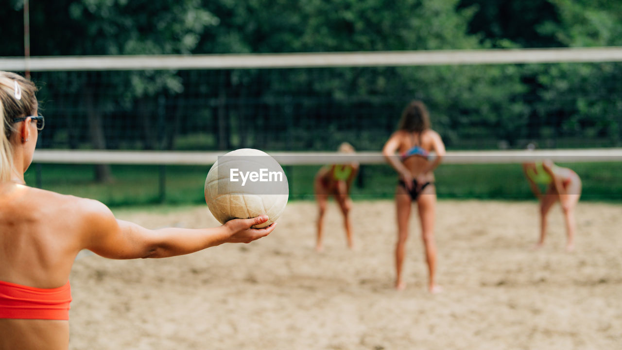 Beach volleyball, female player serving the ball