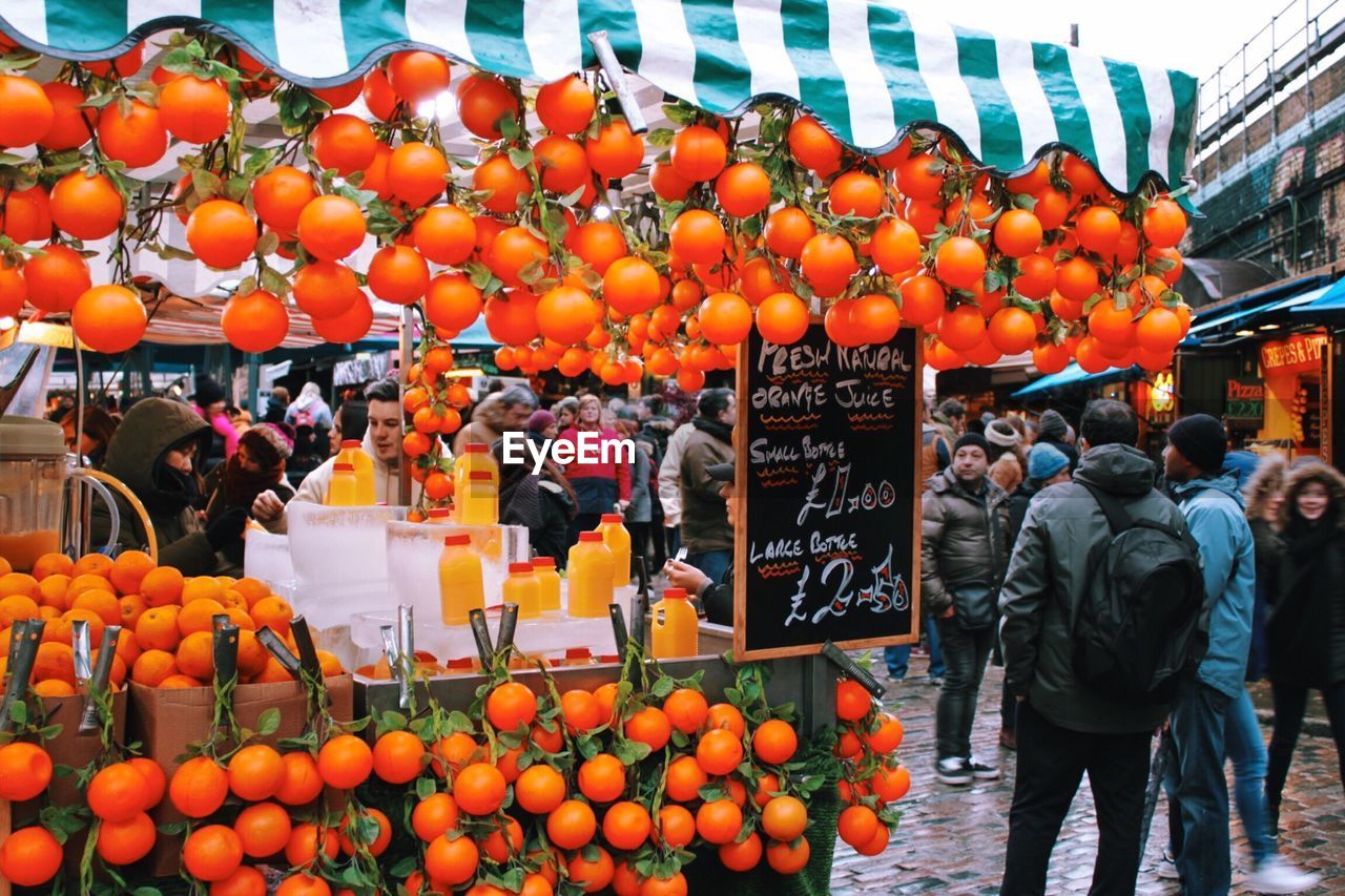 Oranges hanging on market stall in city