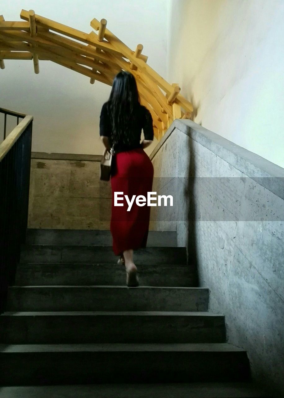 LOW ANGLE VIEW OF WOMAN WALKING ON STEPS