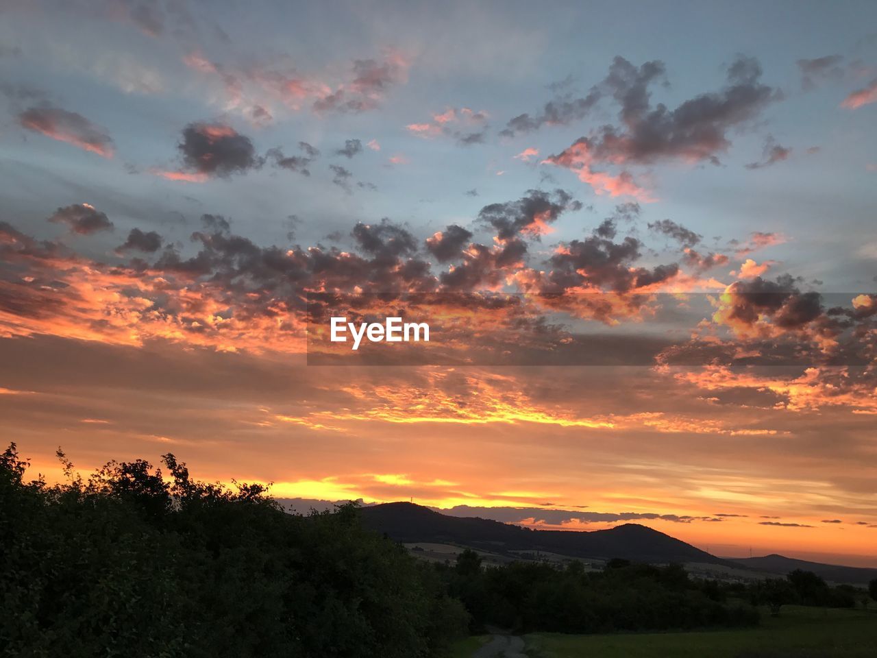 SCENIC VIEW OF DRAMATIC SKY OVER LANDSCAPE DURING SUNSET