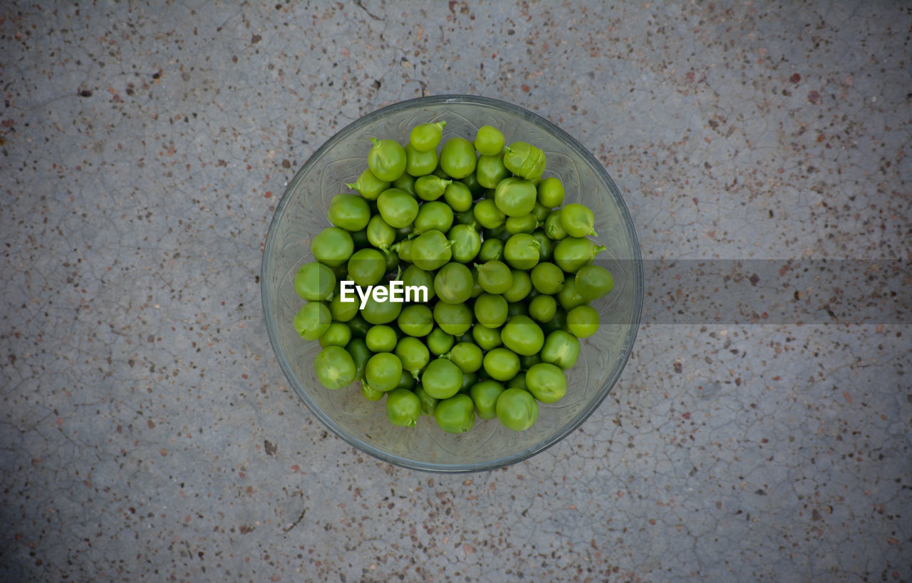 HIGH ANGLE VIEW OF GREEN FRUITS IN CONTAINER