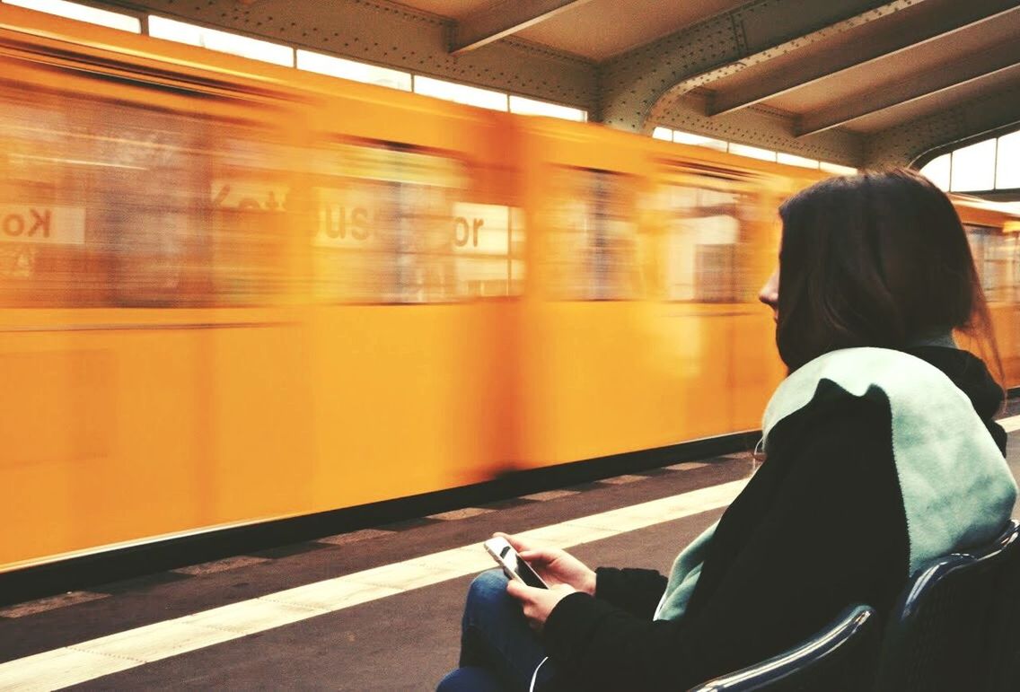 WOMAN SITTING ON TRAIN STATION