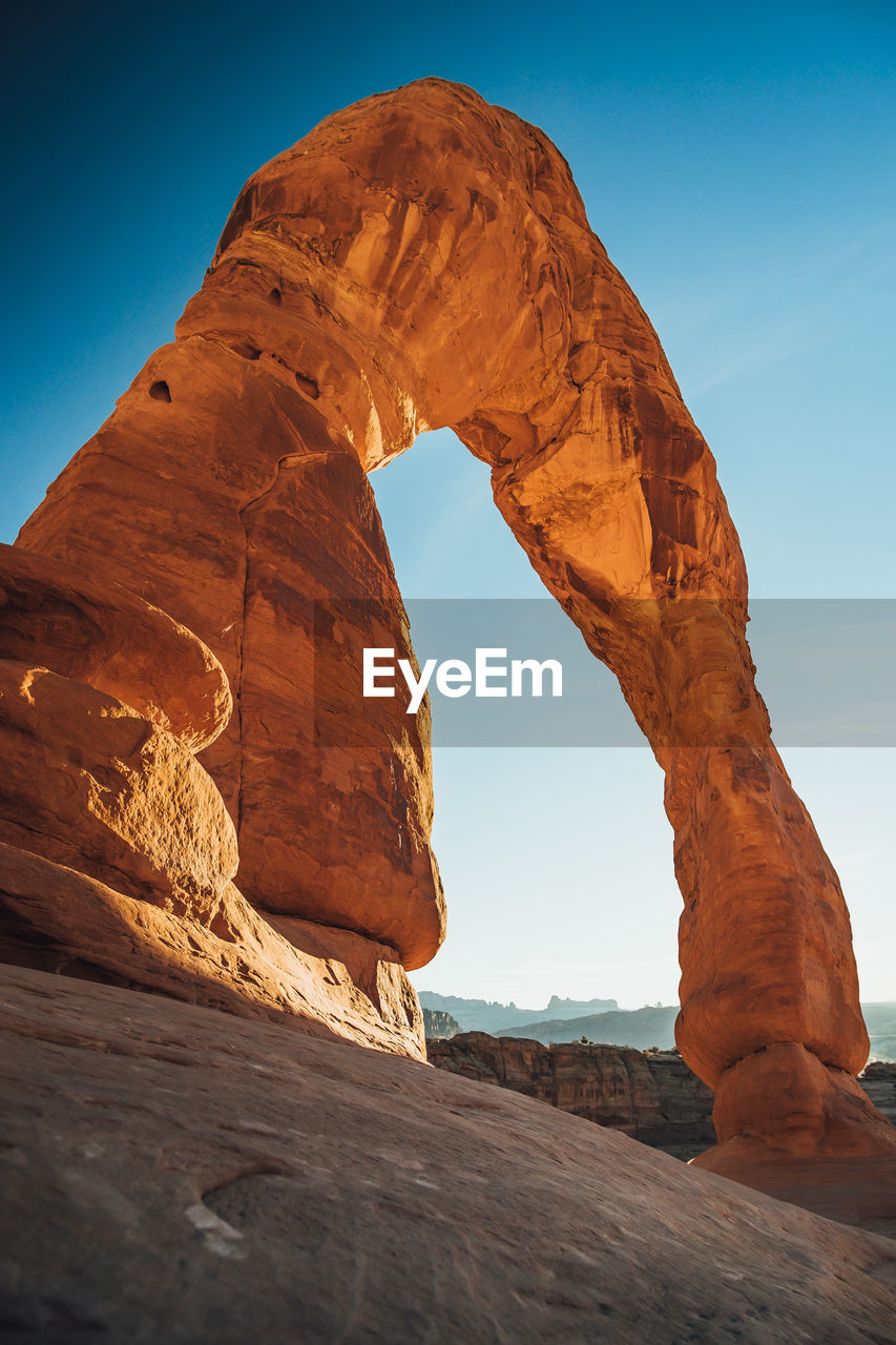 Low angle view of natural arch on rock formation against sky