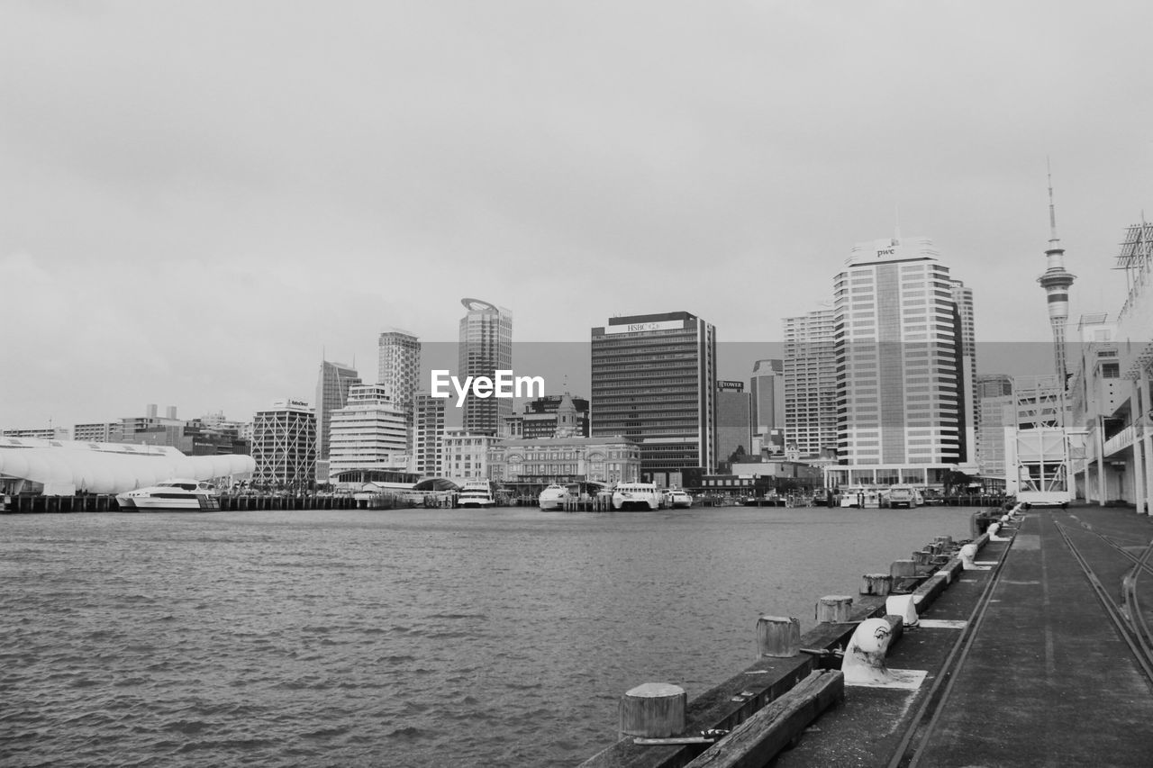 MODERN CITYSCAPE BY RIVER AGAINST SKY