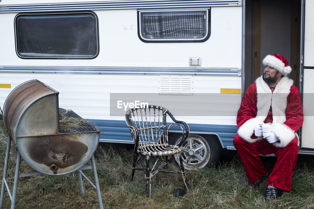 Man wearing santa costume while sitting in motor home