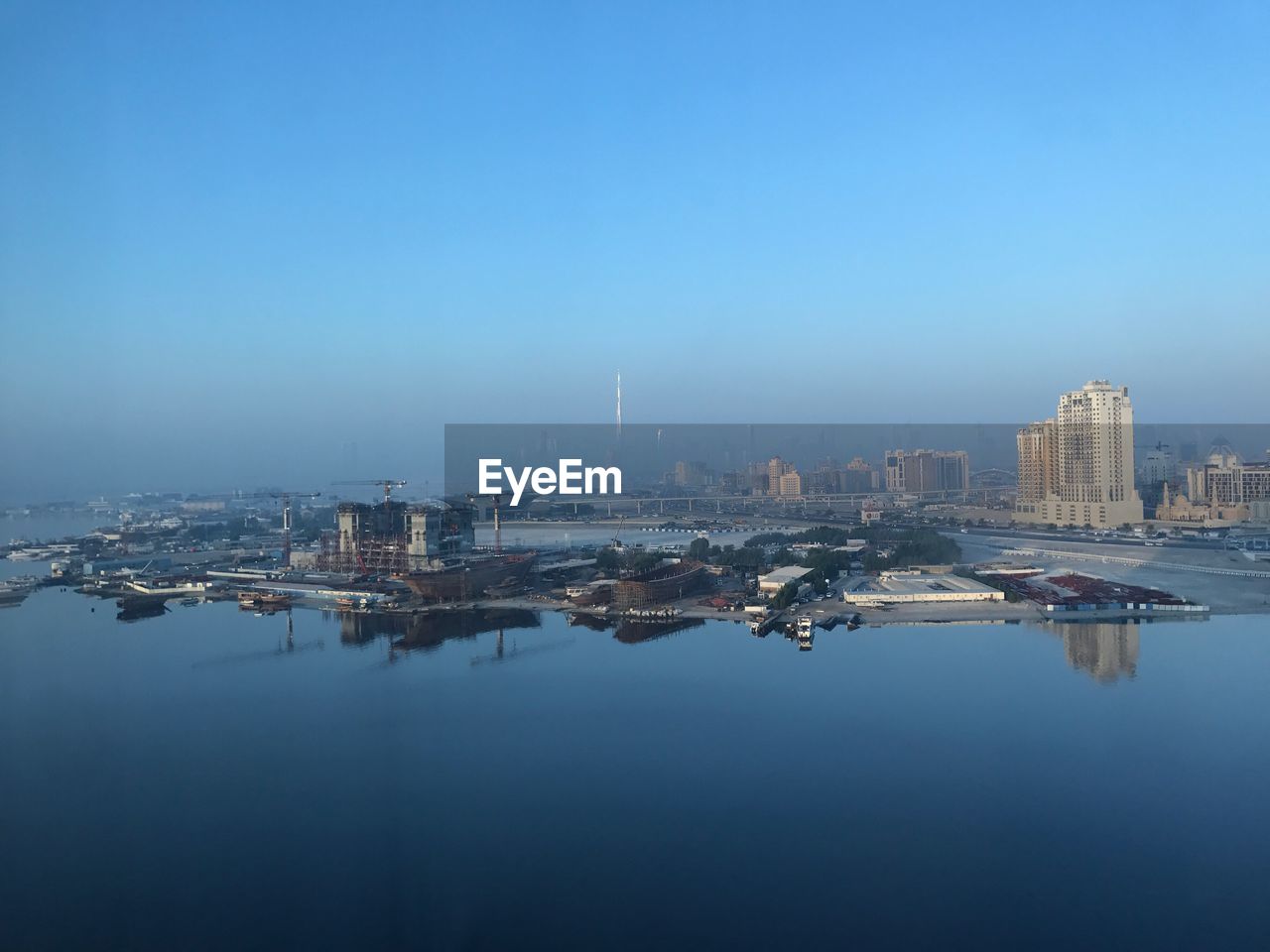 City at waterfront against clear sky