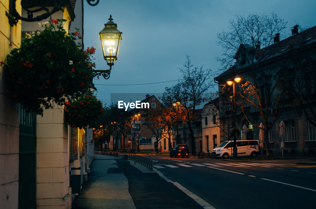 Empty streets of zagreb, croatia illuminated by lamps in the street during a cloudy early evening.