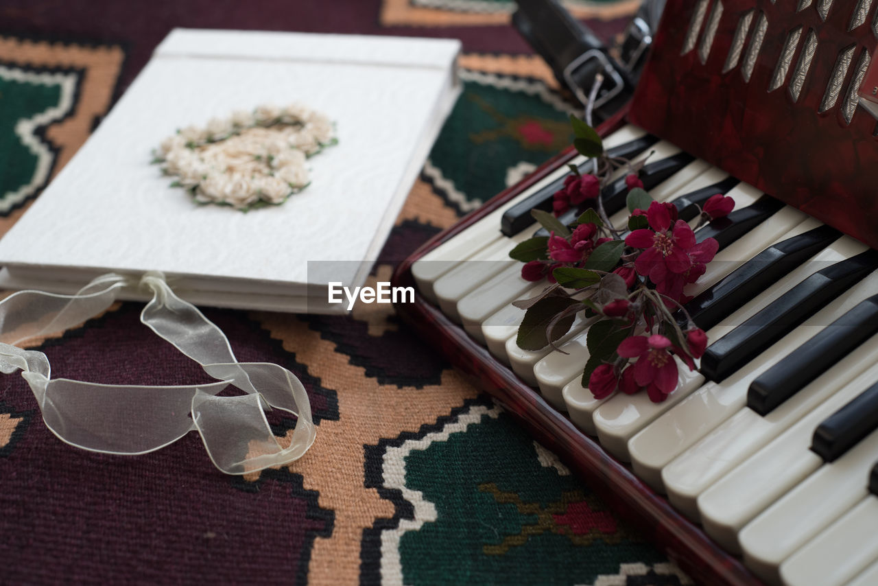 High angle view of harmonica keys and book with flowers