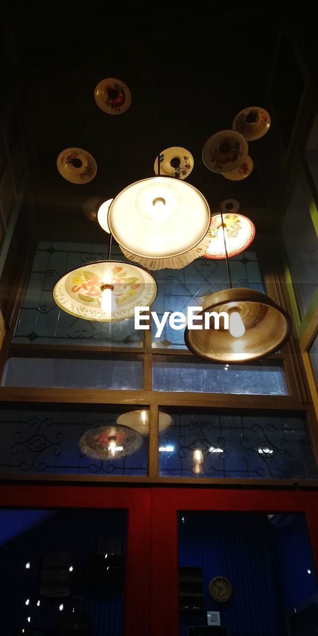 LOW ANGLE VIEW OF ILLUMINATED PENDANT LIGHT BULB