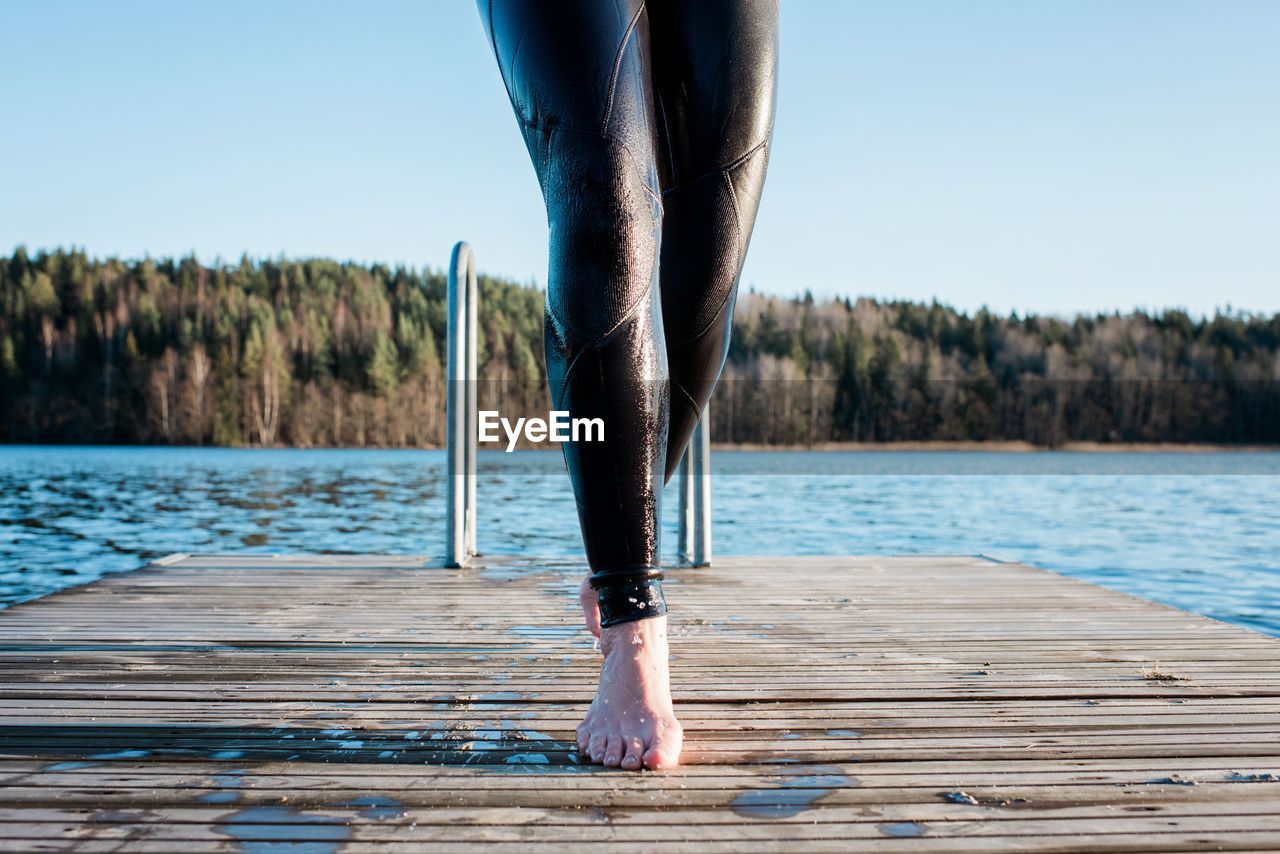 Woman's wet leg's walking along a pier after cold water ice swimming