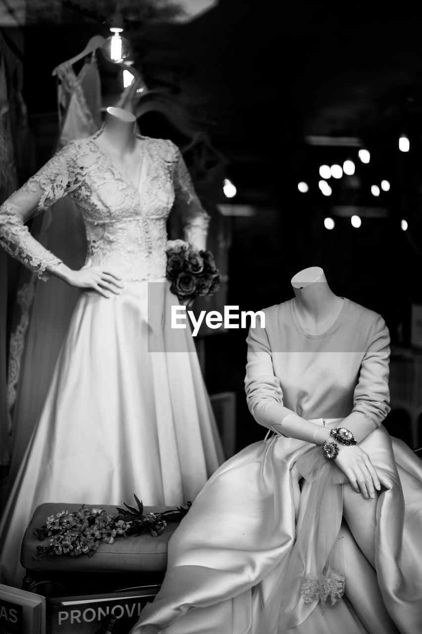 Mannequins wearing dresses seen from window display