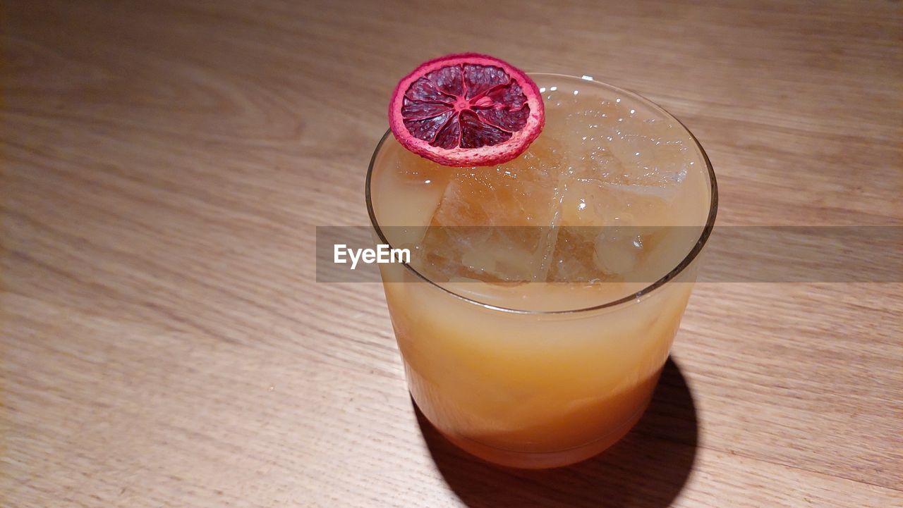 HIGH ANGLE VIEW OF DRINK ON GLASS TABLE