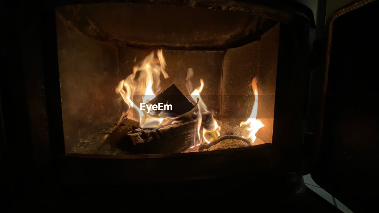 CLOSE-UP OF BURNING CANDLES IN WOOD