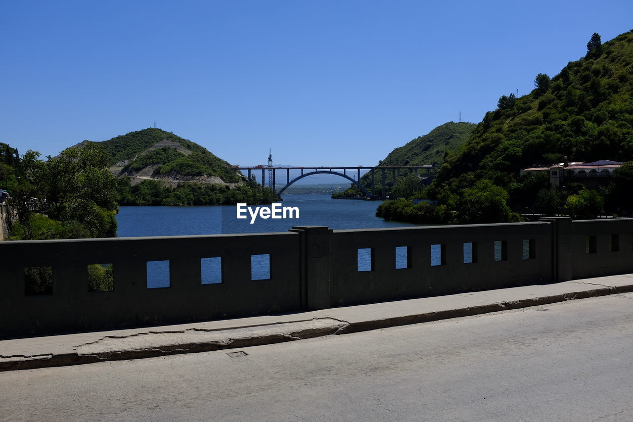 Bridge by road against clear blue sky