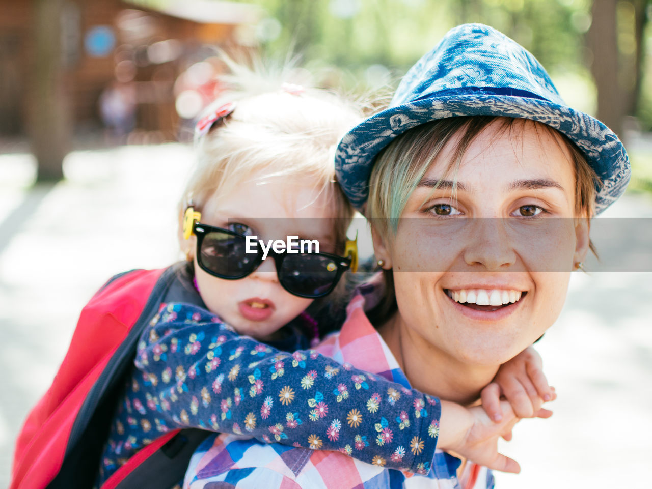 Portrait of smiling mother giving piggyback ride to daughter