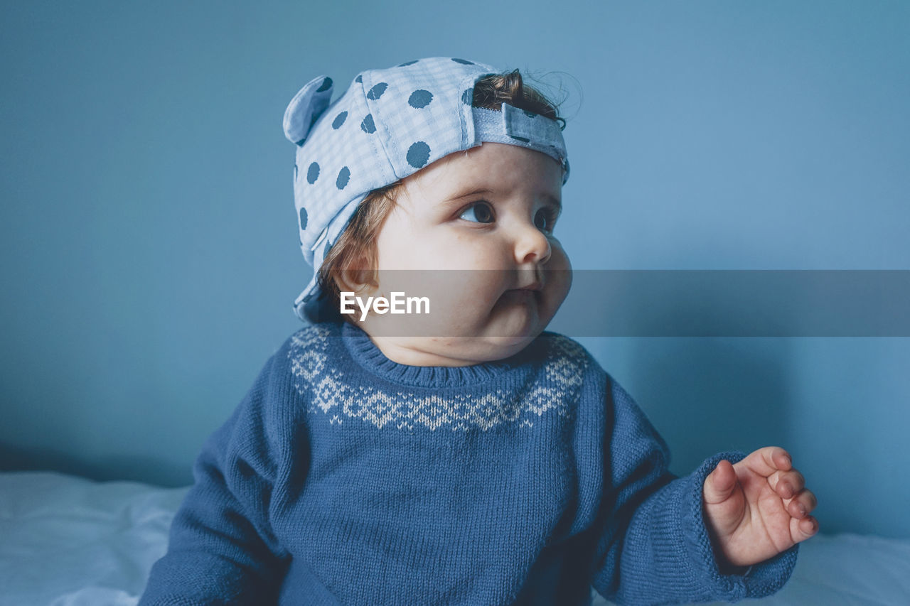 Close-up of baby girl wearing cap at home