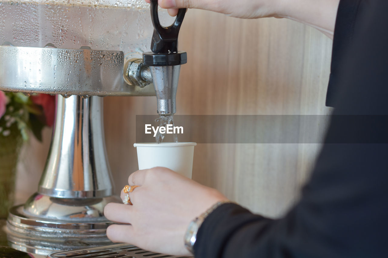 hand, adult, one person, coffee, indoors, business, occupation, drink, food and drink, working, close-up, holding, pouring, home appliance, women, refreshment, coffee cup, cup, small business, making, metal, business finance and industry, mug, selective focus, coffeemaker, cafe
