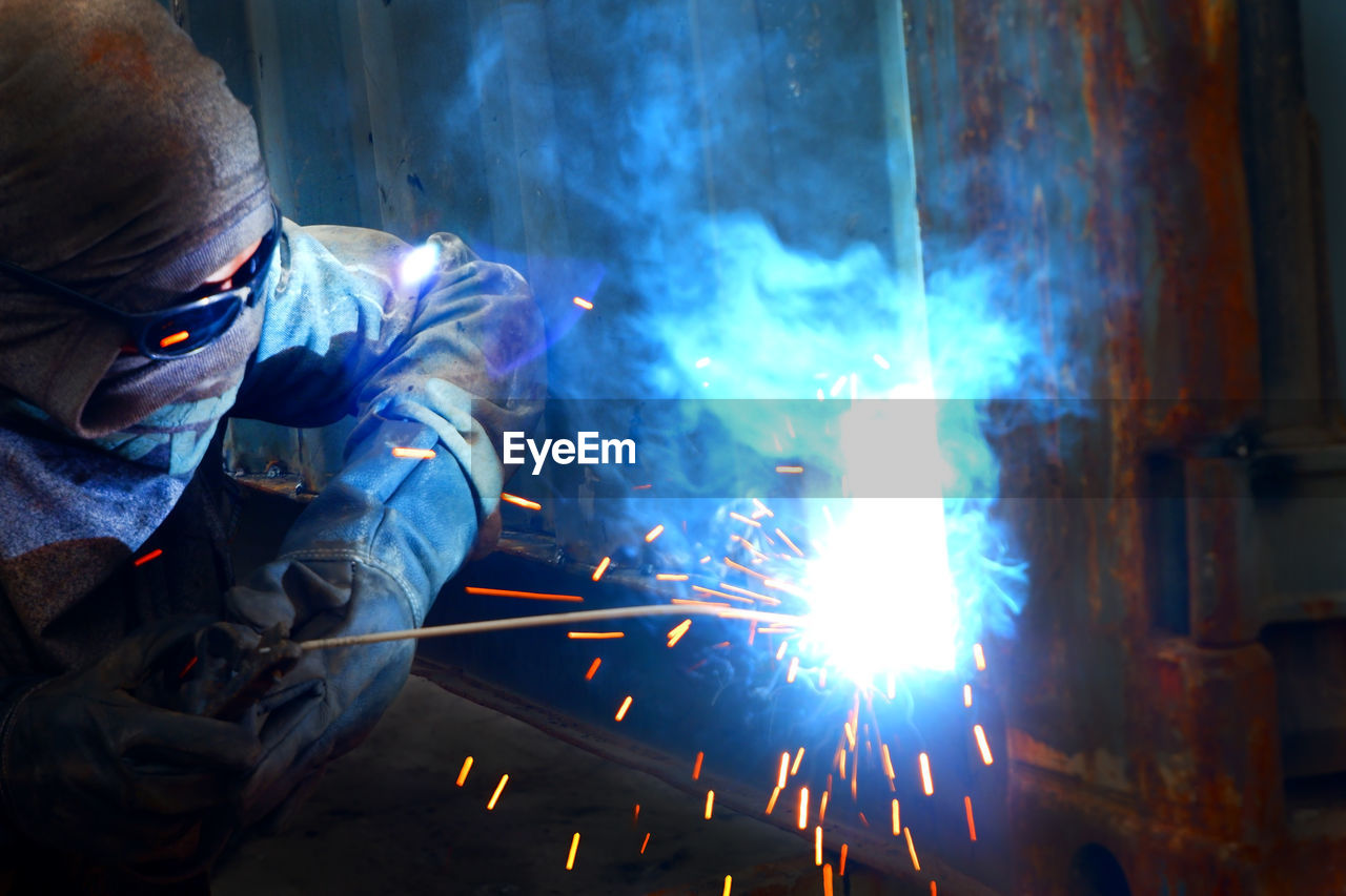 Man welding metal at factory