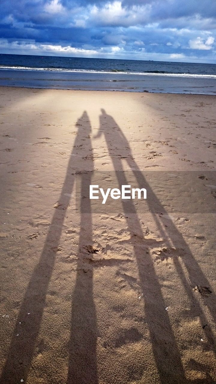 SHADOW OF MAN ON BEACH