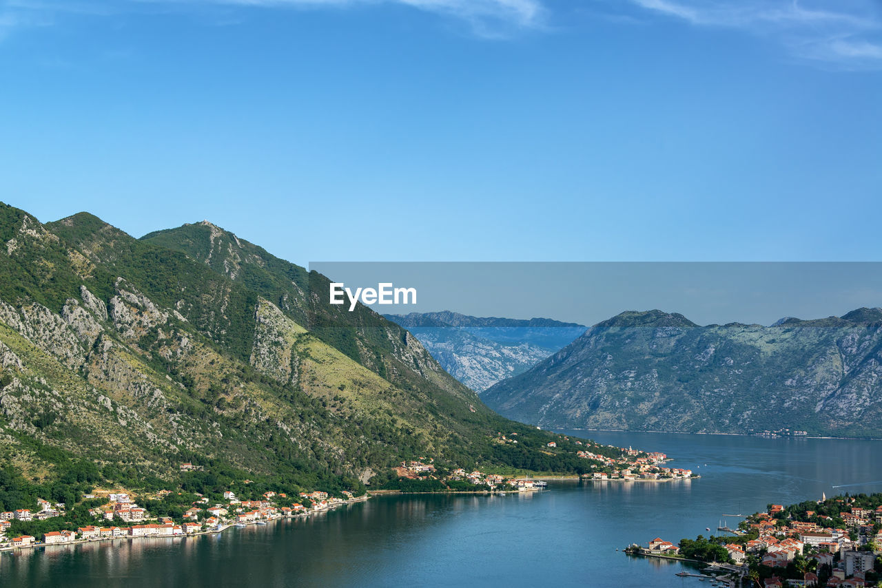 SCENIC VIEW OF LAKE BY MOUNTAINS AGAINST BLUE SKY