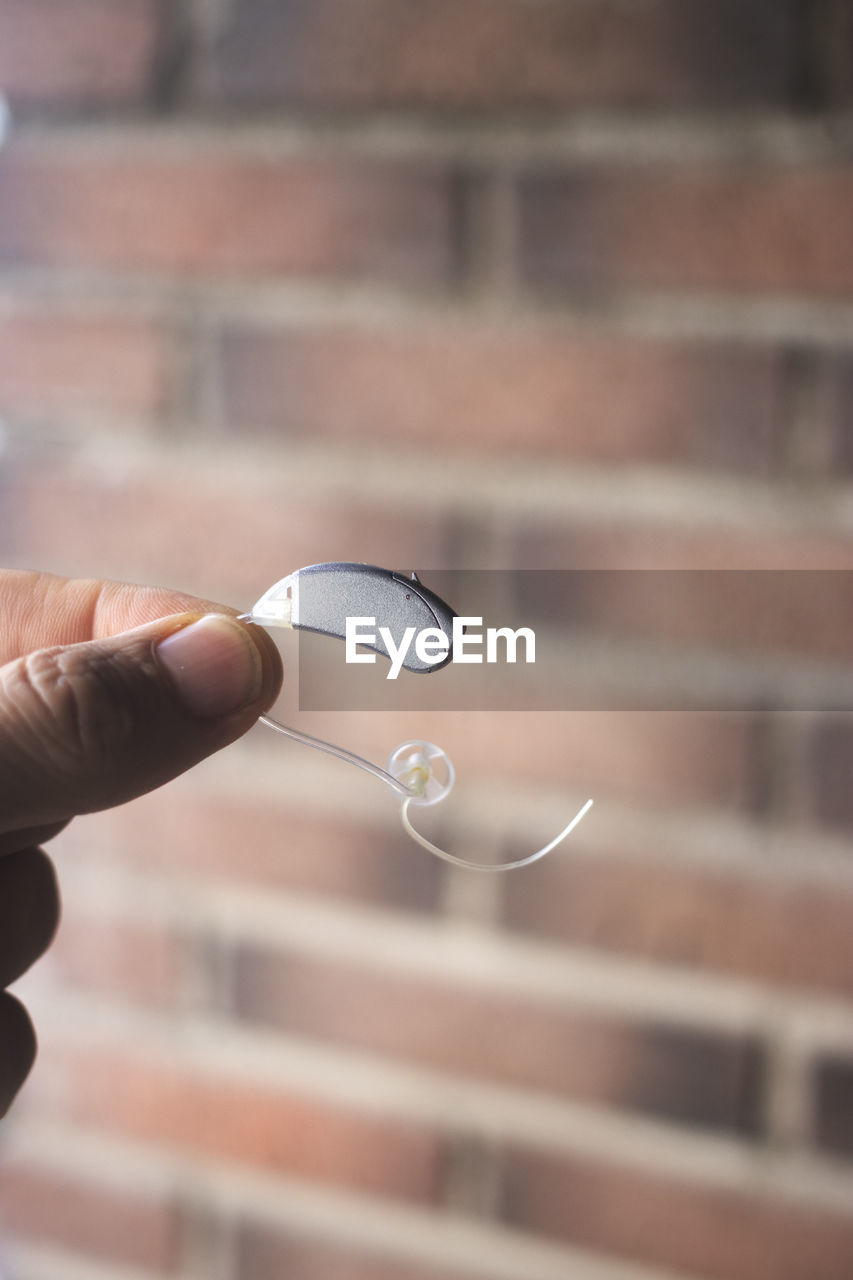 Close-up of hand holding hearing aid