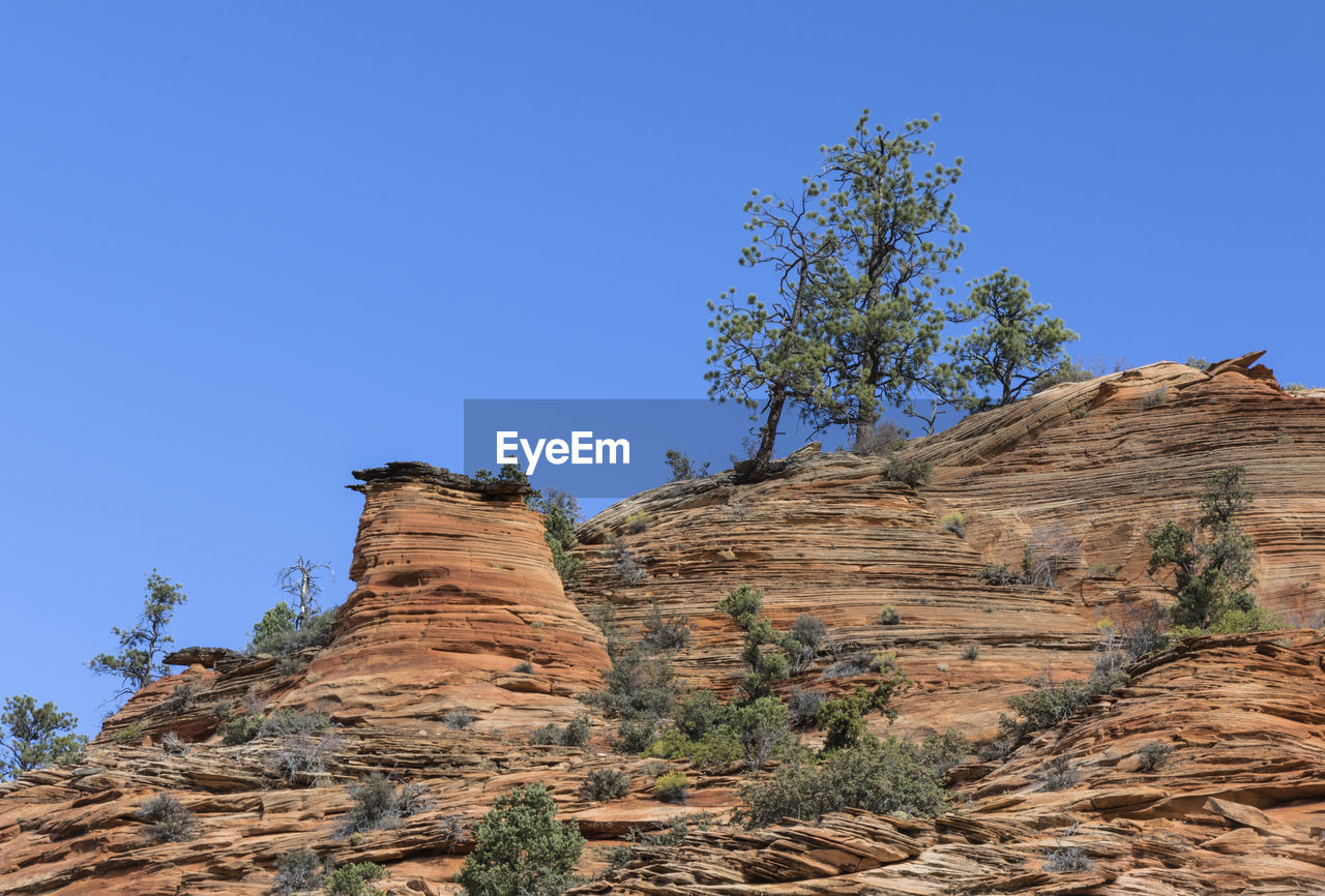 LOW ANGLE VIEW OF ROCK FORMATION AGAINST CLEAR SKY