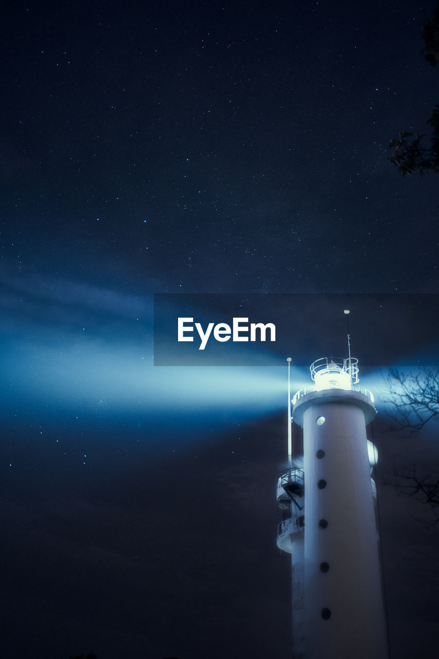 Lighthouse against sky at night