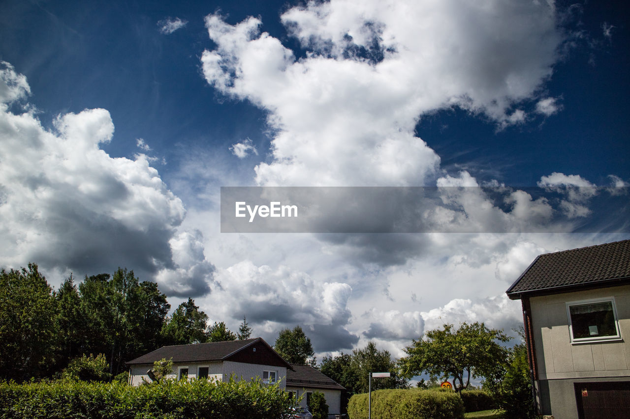 VIEW OF HOUSES AGAINST CLOUDY SKY