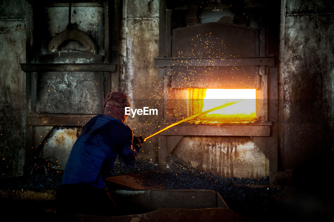 Man melting iron at factory