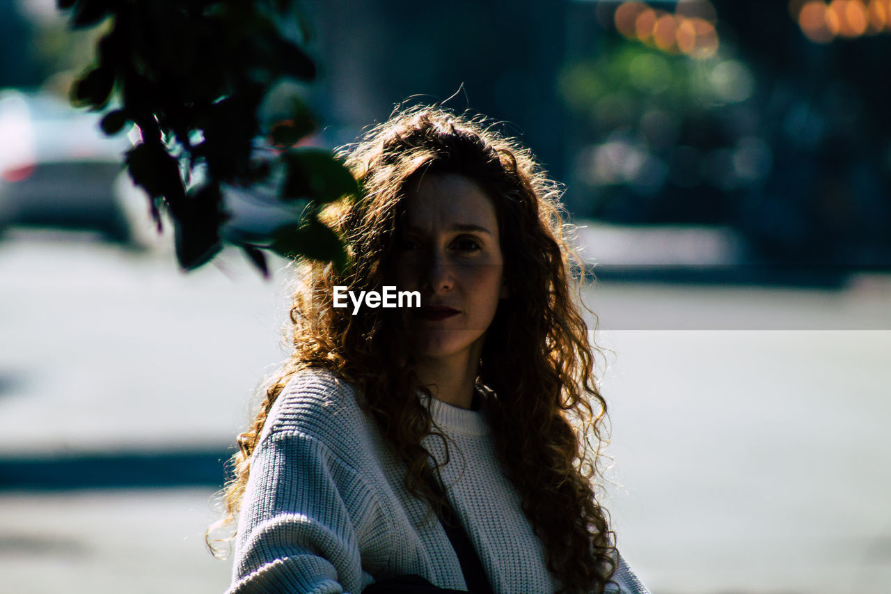 PORTRAIT OF YOUNG WOMAN WITH HAIR OUTDOORS