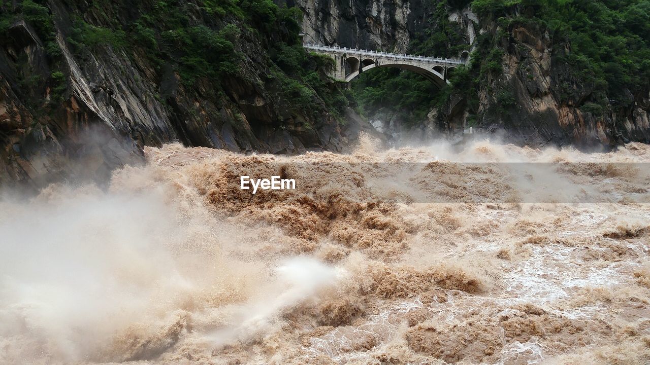 SCENIC VIEW OF WATERFALL OVER BRIDGE