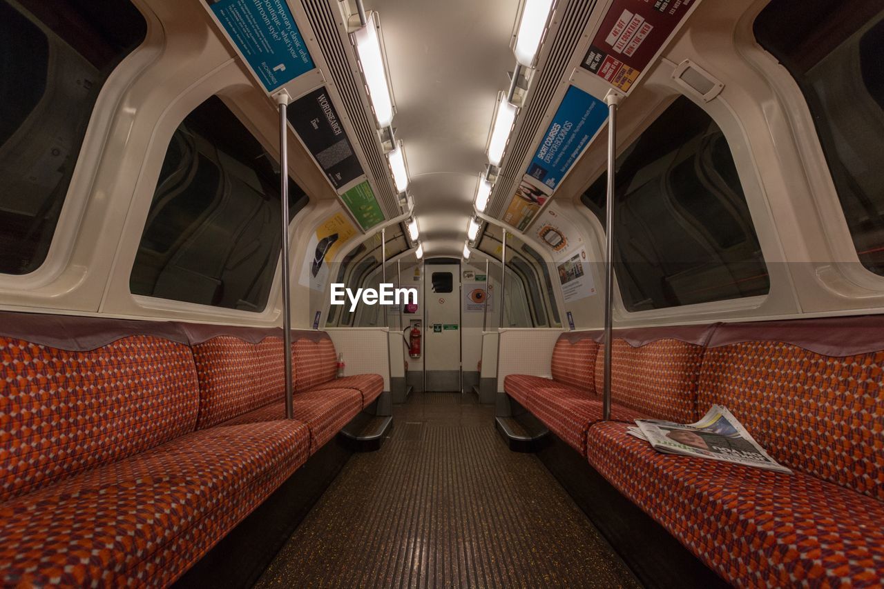 VIEW OF TRAIN PASSING THROUGH ILLUMINATED BUS