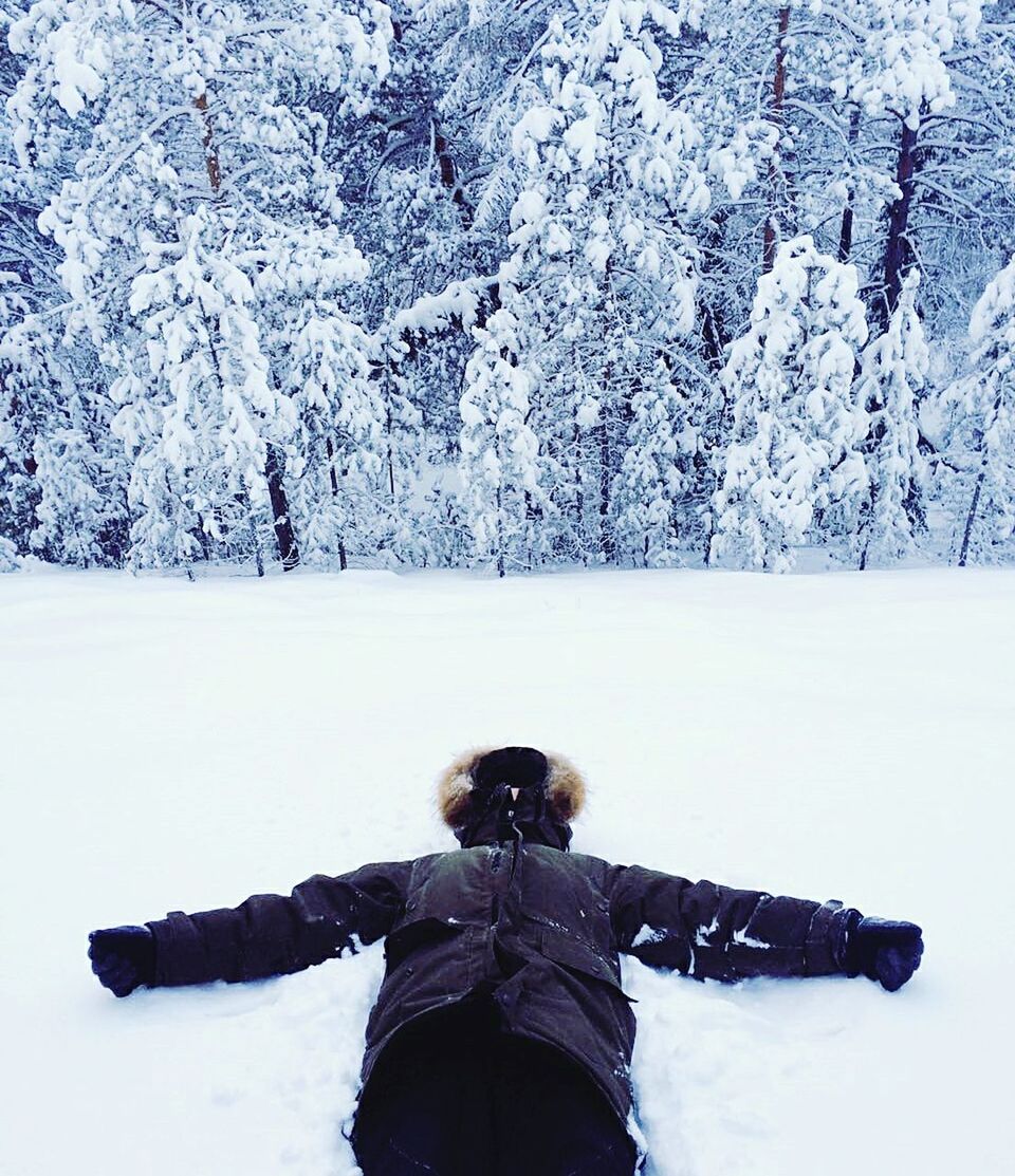 Person lying on snow covered landscape