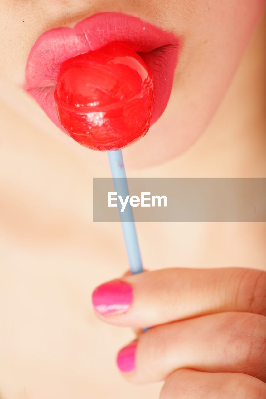 Cropped image of woman eating lollipop