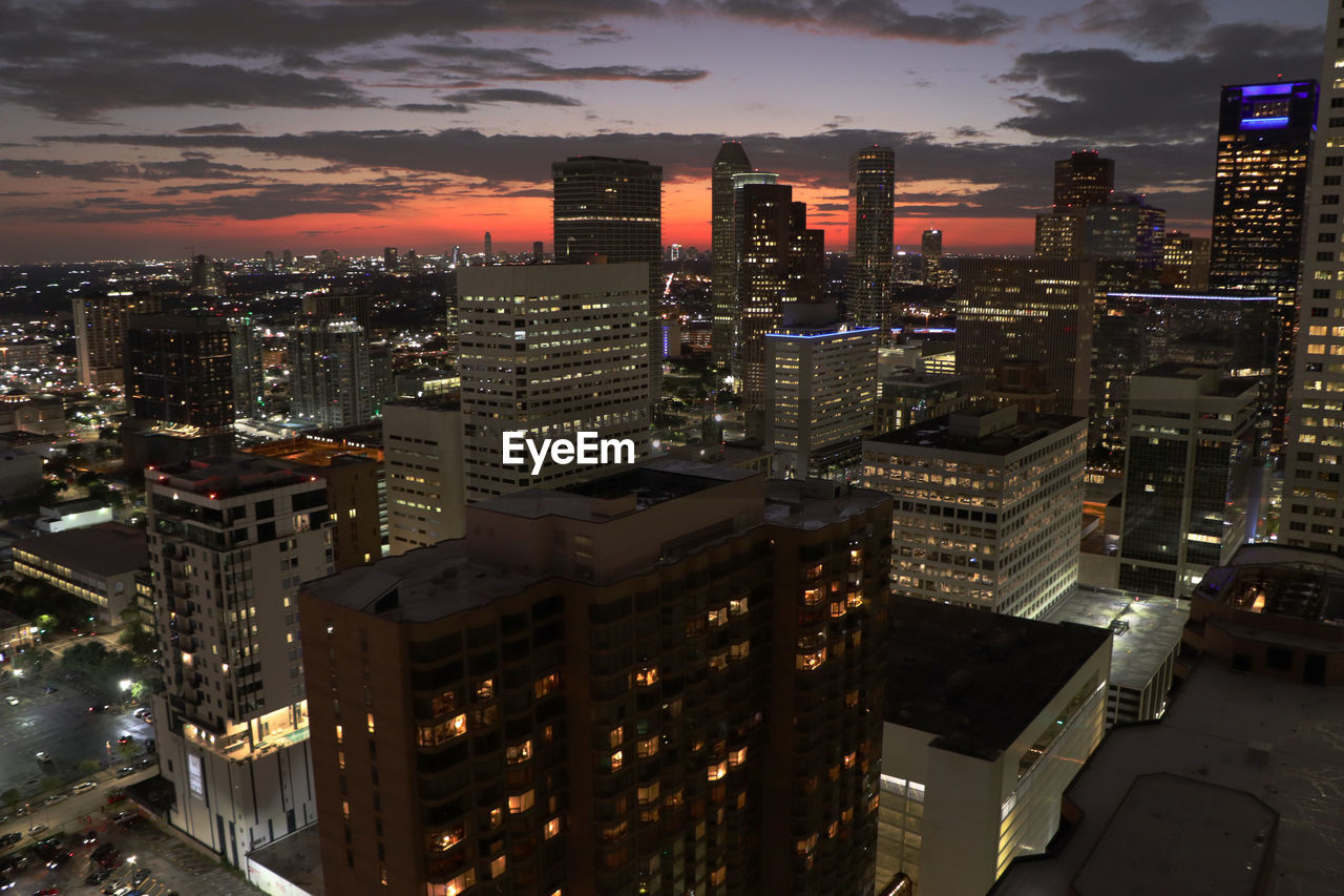 HIGH ANGLE VIEW OF ILLUMINATED BUILDINGS AT NIGHT