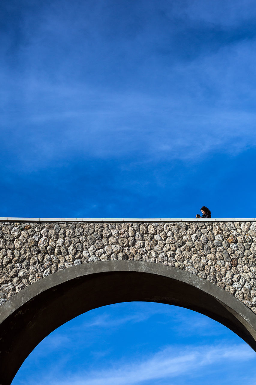 LOW ANGLE VIEW OF BUILT STRUCTURE AGAINST BLUE SKY