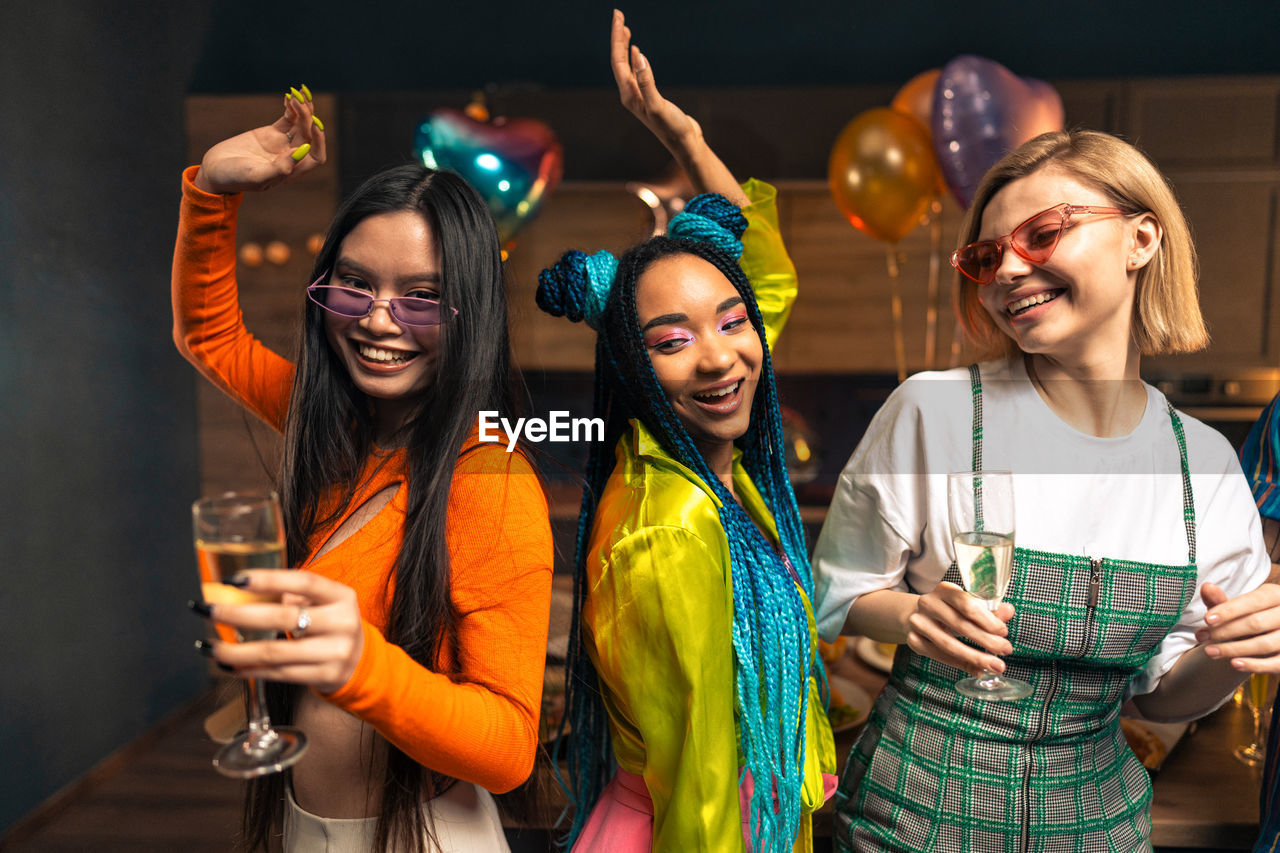 portrait of smiling friends with hands in party at night