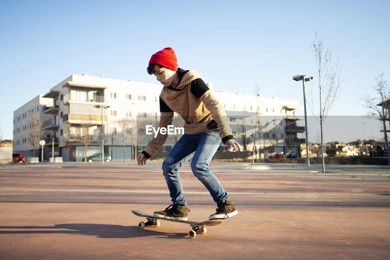 Male skateboarder riding and practicing skateboard in city outdoors