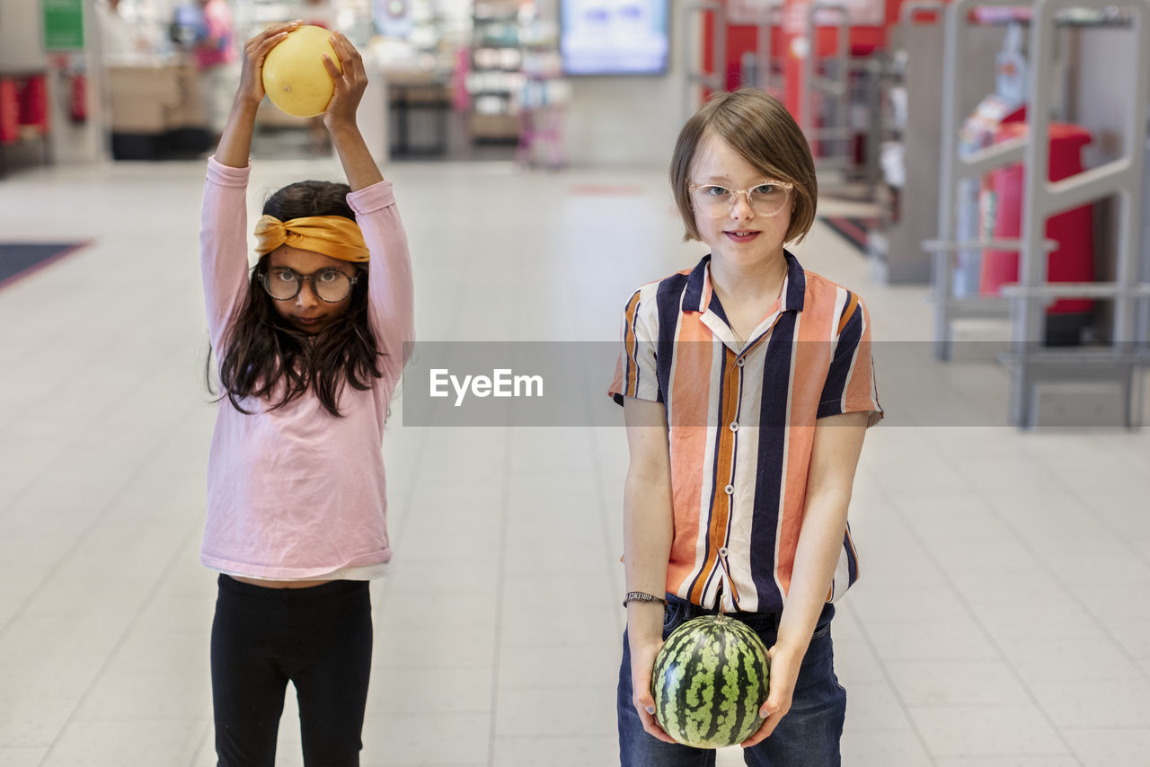 Girl in supermarket holding fruits