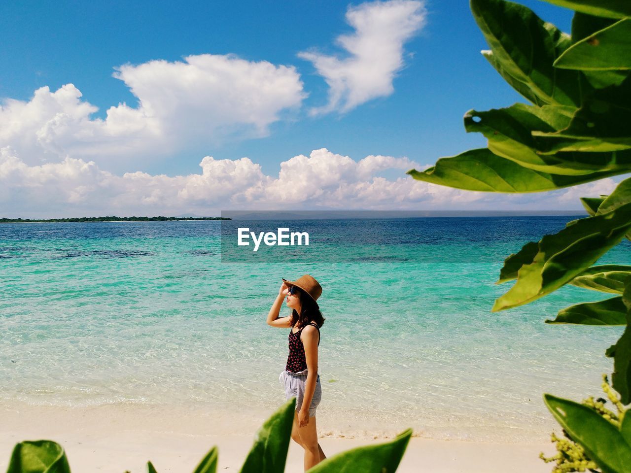 Woman walking at beach against sky