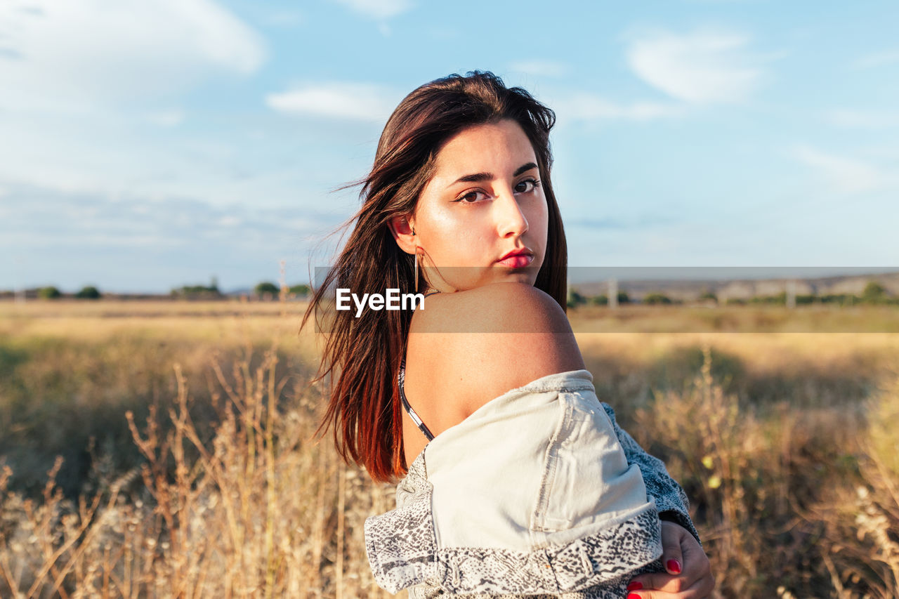 Beautiful teenager posing sideways in the countryside