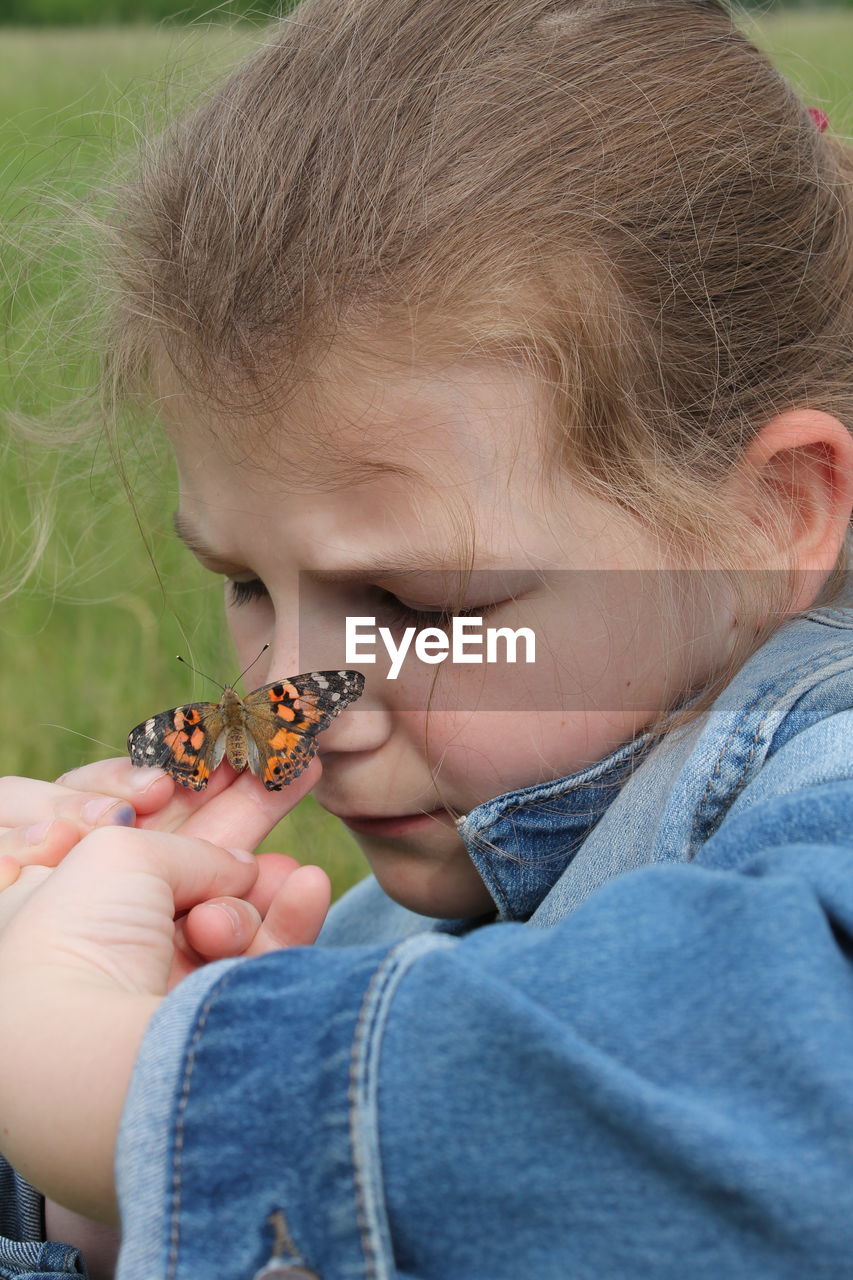 Close-up of girl playing with butterfly