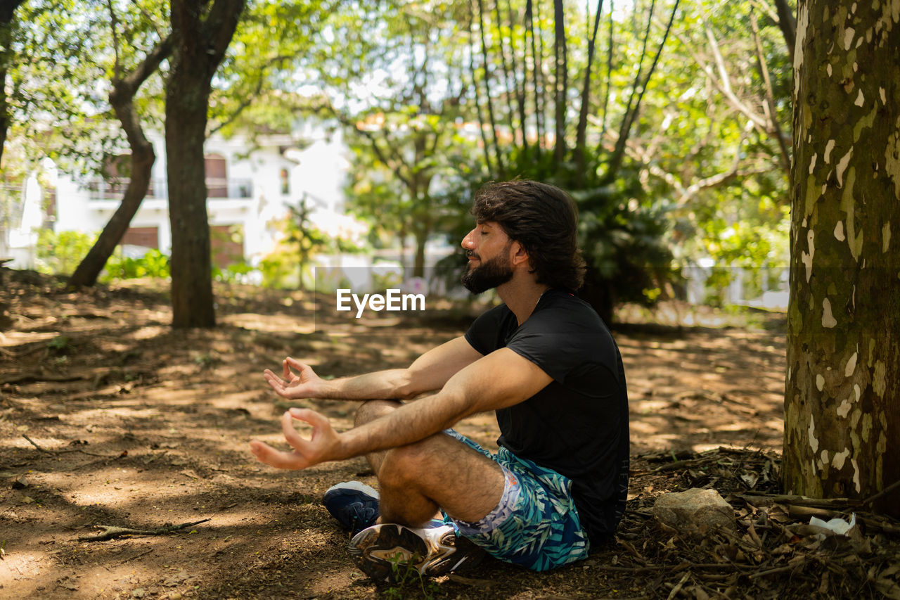Man meditating. yoga and meditation on a sunny.day at a park. feel good, healthy, spiritual concept.