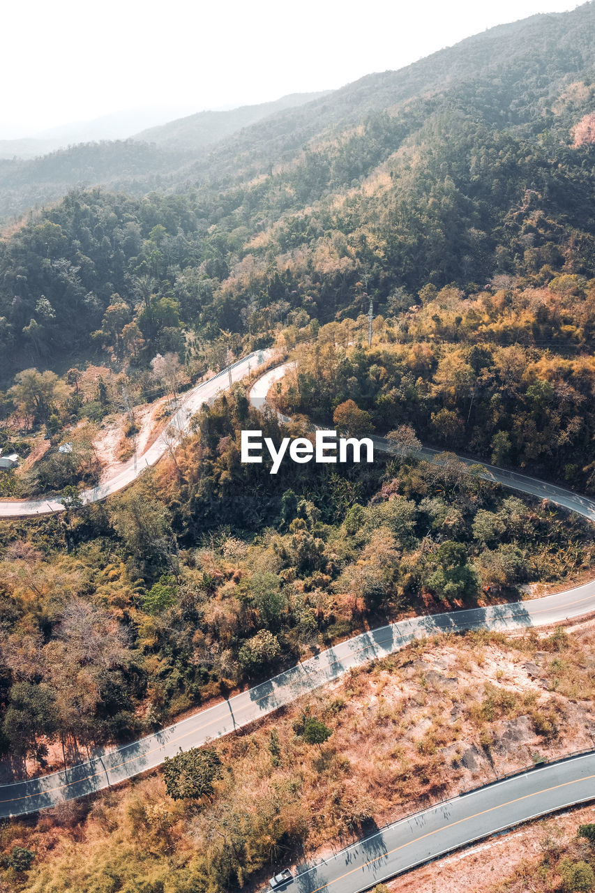 Aerial view of road amidst trees against sky