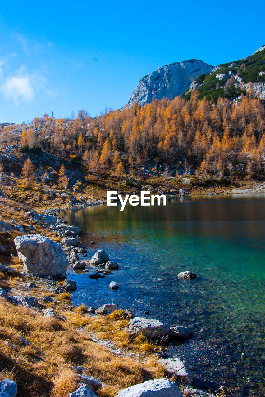 Scenic view of lake by mountain against sky