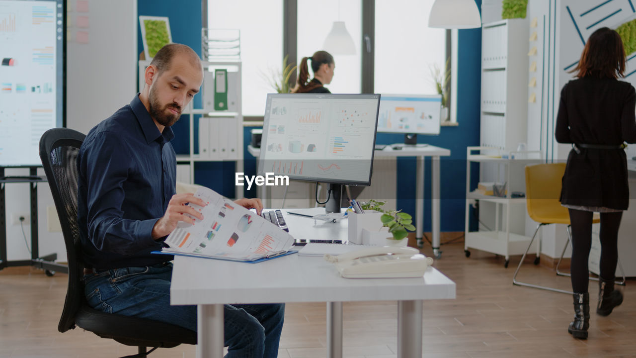 Man examining chart and graph documents at office