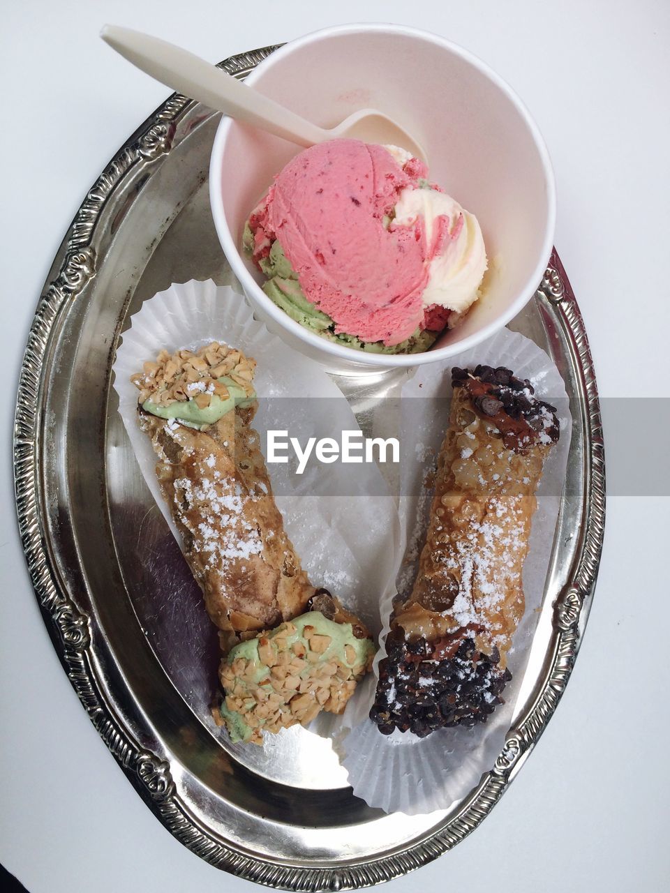 Cannolis and ice cream served in plate on table