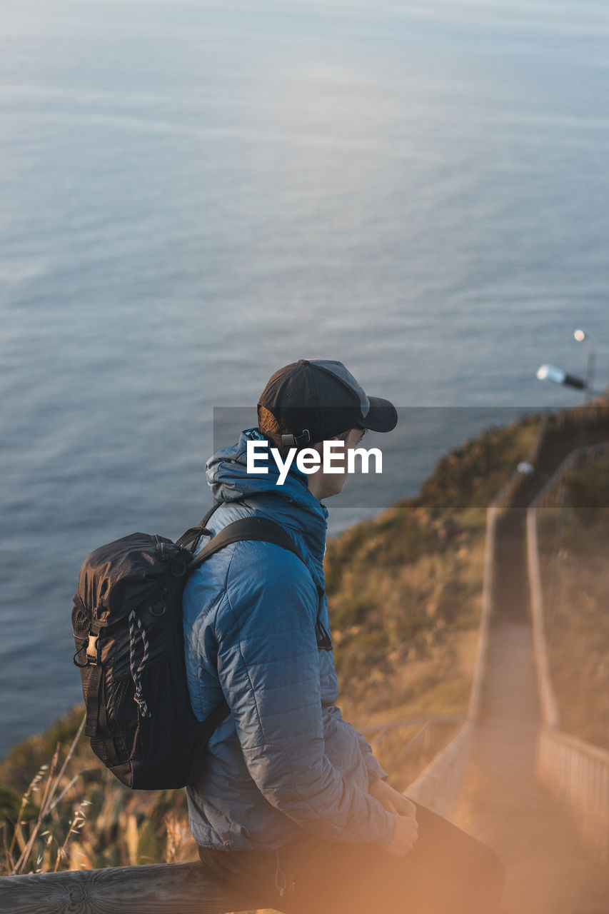 Student wearing a jacket enjoys the view from cristo rei, camara de lomos, madeira, portugal