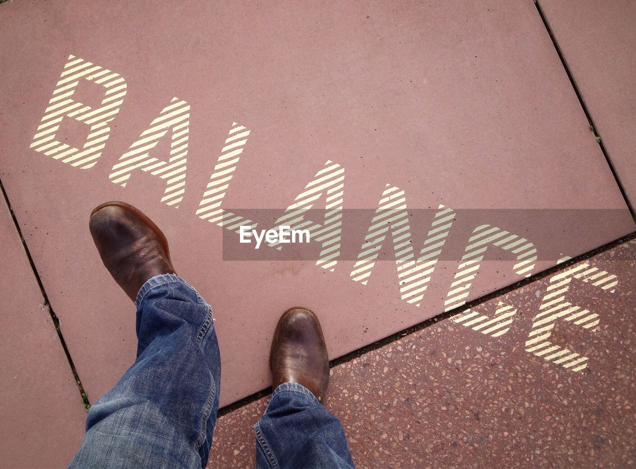 LOW SECTION OF PERSON STANDING ON TILED FLOOR